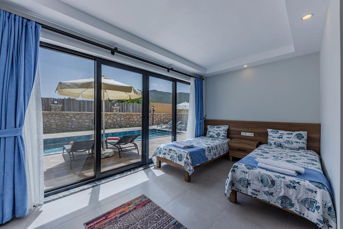 La quatrième chambre, deux lits simples et baie vitrée sur la piscine